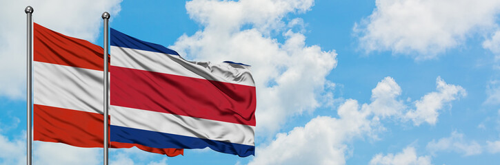 Austria and Costa Rica flag waving in the wind against white cloudy blue sky together. Diplomacy concept, international relations.