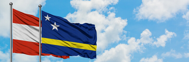 Austria and Curacao flag waving in the wind against white cloudy blue sky together. Diplomacy concept, international relations.