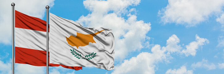 Austria and Cyprus flag waving in the wind against white cloudy blue sky together. Diplomacy concept, international relations.