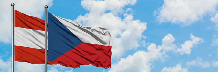 Fototapeta na wymiar Austria and Czech Republic flag waving in the wind against white cloudy blue sky together. Diplomacy concept, international relations.