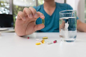 Young man holding pharmaceutical medicine pills in hand