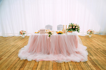 Beautiful festive table for newlyweds, overall plan. Champagne bottles decorated with lace. White...