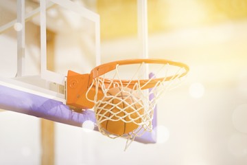 Fototapeta na wymiar Adidas Basketball ball hitting basket in gym