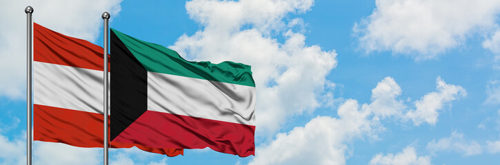 Obraz premium Austria and Kuwait flag waving in the wind against white cloudy blue sky together. Diplomacy concept, international relations.