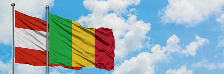 Austria and Mali flag waving in the wind against white cloudy blue sky together. Diplomacy concept, international relations.