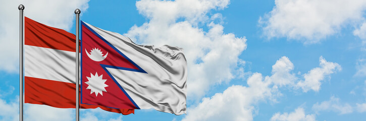 Austria and Nepal flag waving in the wind against white cloudy blue sky together. Diplomacy concept, international relations.