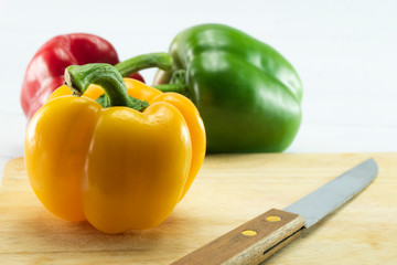 Closeup  fresh  Red, Yellow, Green, bell pepper or sweet pepper or capsicum  isolate on  chopping wood on white background ,raw food ingredient concept.