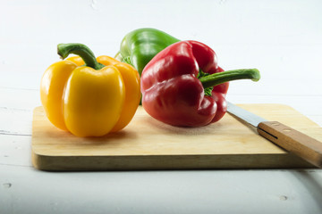 Closeup  fresh  Red, Yellow, Green, bell pepper or sweet pepper or capsicum  isolate on  chopping wood on white background ,raw food ingredient concept.
