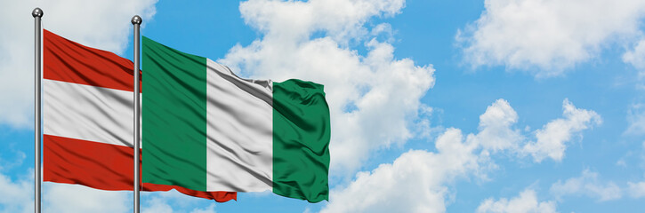 Austria and Nigeria flag waving in the wind against white cloudy blue sky together. Diplomacy concept, international relations.