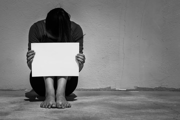 Desperate woman holding a blank sign to protest, on the street.
