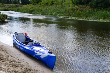 Kayak by the sandy bank of the river
