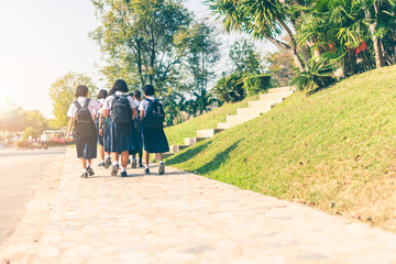 The Asian female high school students in white uniform are going back home after school .