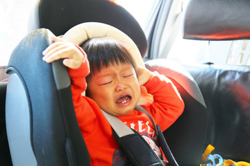 Asian boy crying when he sit on car seat. Baby in car.