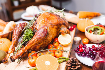 Roasted  chicken or turkey with sauce and grilled autumn vegetables: corn,pumpkin  on wooden table, top view, frame. Christmas or Thanksgiving Day food concept.