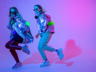 Young stylish girls dancing in the Studio on a colored neon background. Music dj poster design.