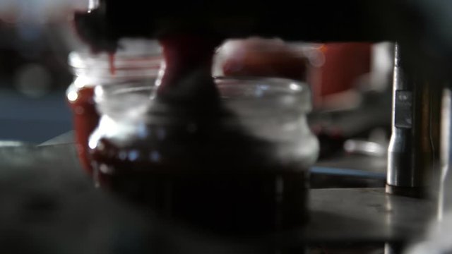 Rolling robotic hands filling the moving banks with tomato paste on a plant