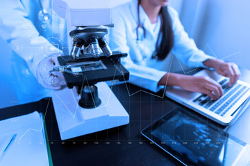 Asian female doctor working on laptop with a microscope for an exam at hospital giving patient convenience online service advice, smiling write a prescription , healthcare, preventing disease concept