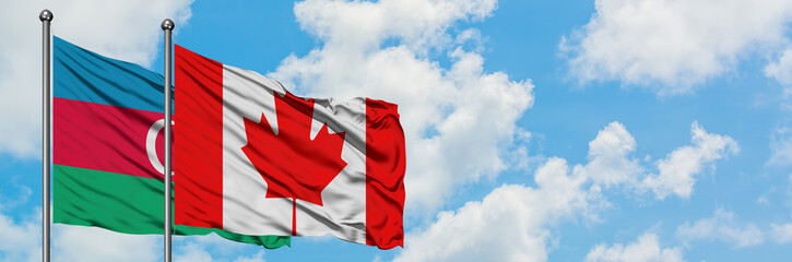 Azerbaijan and Canada flag waving in the wind against white cloudy blue sky together. Diplomacy concept, international relations.