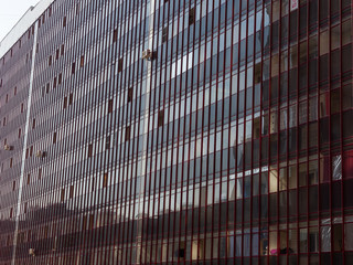 Dark glass wall of a huge residential building. The theme of an emerging housing market under...