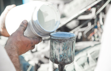 Paint in the hand of a painter. Painting car details