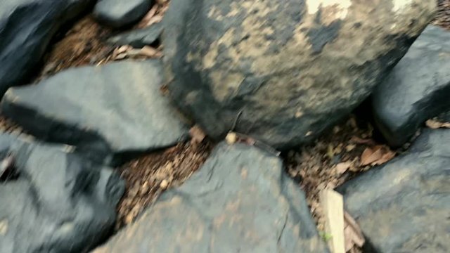 POV jumping on big black rocks and a close view of the landscape.