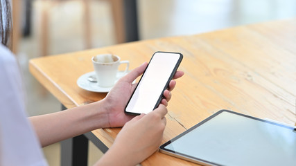 Close-up woman doctor holding het smartphone mockup empty screen.