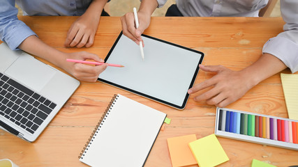 Attractive creative meeting with digital tablet on wood table.