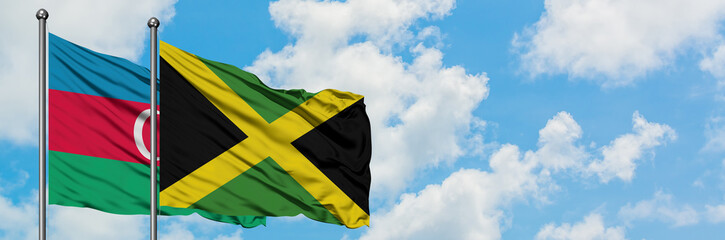 Azerbaijan and Jamaica flag waving in the wind against white cloudy blue sky together. Diplomacy concept, international relations.