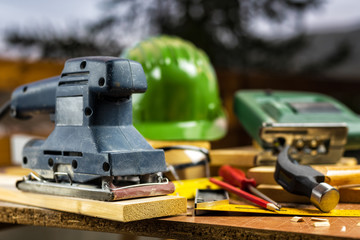 Fototapeta na wymiar Electric sander for carpenter, carpentry tools on a work table. Construction industry, housework do it yourself. Stock photography.