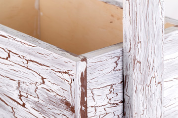Detail of a wooden box with aged paint close-up on a white background