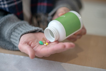Close up of man taking pills and vitamins in the morning