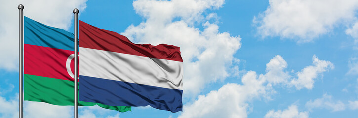 Azerbaijan and Netherlands flag waving in the wind against white cloudy blue sky together. Diplomacy concept, international relations.