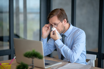 Office worker dealing with seasonal allergy in the office