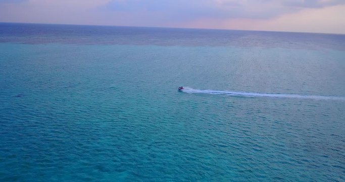 Sunset over water in Malaysia, jet ski running in open water