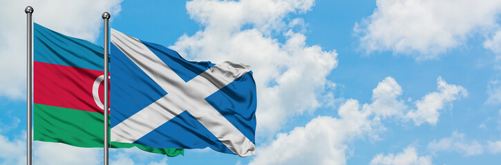 Azerbaijan and Scotland flag waving in the wind against white cloudy blue sky together. Diplomacy concept, international relations.