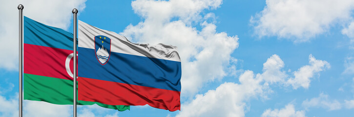 Azerbaijan and Slovenia flag waving in the wind against white cloudy blue sky together. Diplomacy concept, international relations.