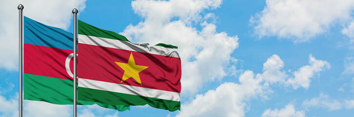 Azerbaijan and Suriname flag waving in the wind against white cloudy blue sky together. Diplomacy concept, international relations.