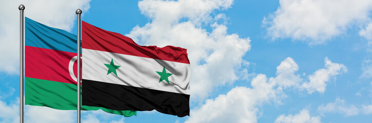 Azerbaijan and Syria flag waving in the wind against white cloudy blue sky together. Diplomacy concept, international relations.