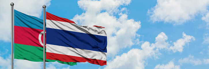 Azerbaijan and Thailand flag waving in the wind against white cloudy blue sky together. Diplomacy concept, international relations.