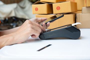 businessman hand using the card machine to pay the goods before packing in the box to deliver to the customer