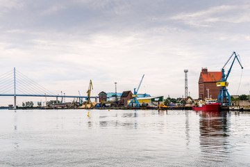 Panoramic view of the commercial harbour of Stralsund with cranes and tugboat.