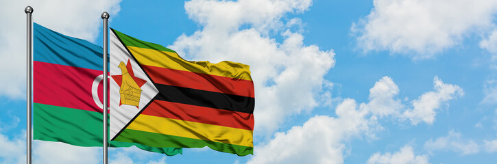 Azerbaijan and Zimbabwe flag waving in the wind against white cloudy blue sky together. Diplomacy concept, international relations.
