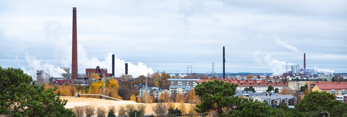 Cityscape, red brick buildings of an old factory, factory chimneys smoke. Ecology problems in Europe.