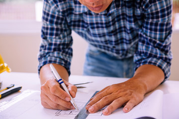 architect man handwriting with blueprint to build houses. After agreeing the employment price the...