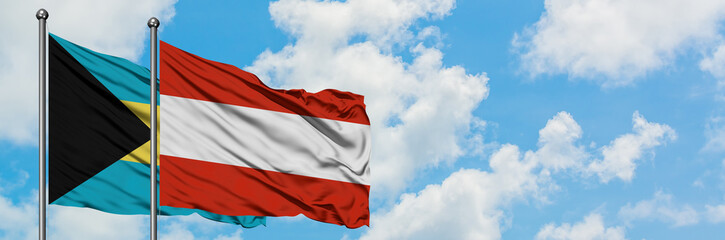 Bahamas and Austria flag waving in the wind against white cloudy blue sky together. Diplomacy concept, international relations.