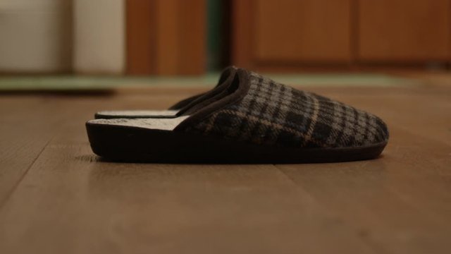 Man waking up, getting out of bed and putting bare cold feet in comfortable pantofle slippers. Close up