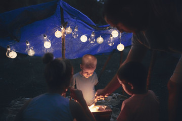 Father with children playing under their backyard tent.