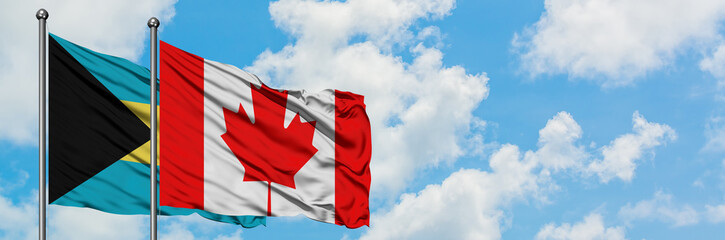 Bahamas and Canada flag waving in the wind against white cloudy blue sky together. Diplomacy concept, international relations.