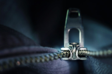 metal zipper macro shot, incisive technical invention for sewing and clothing industries, dark blue-grey background with copy space, selected focus