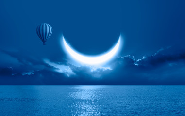 Night sky with crescent moon in the clouds with hot air balloon 